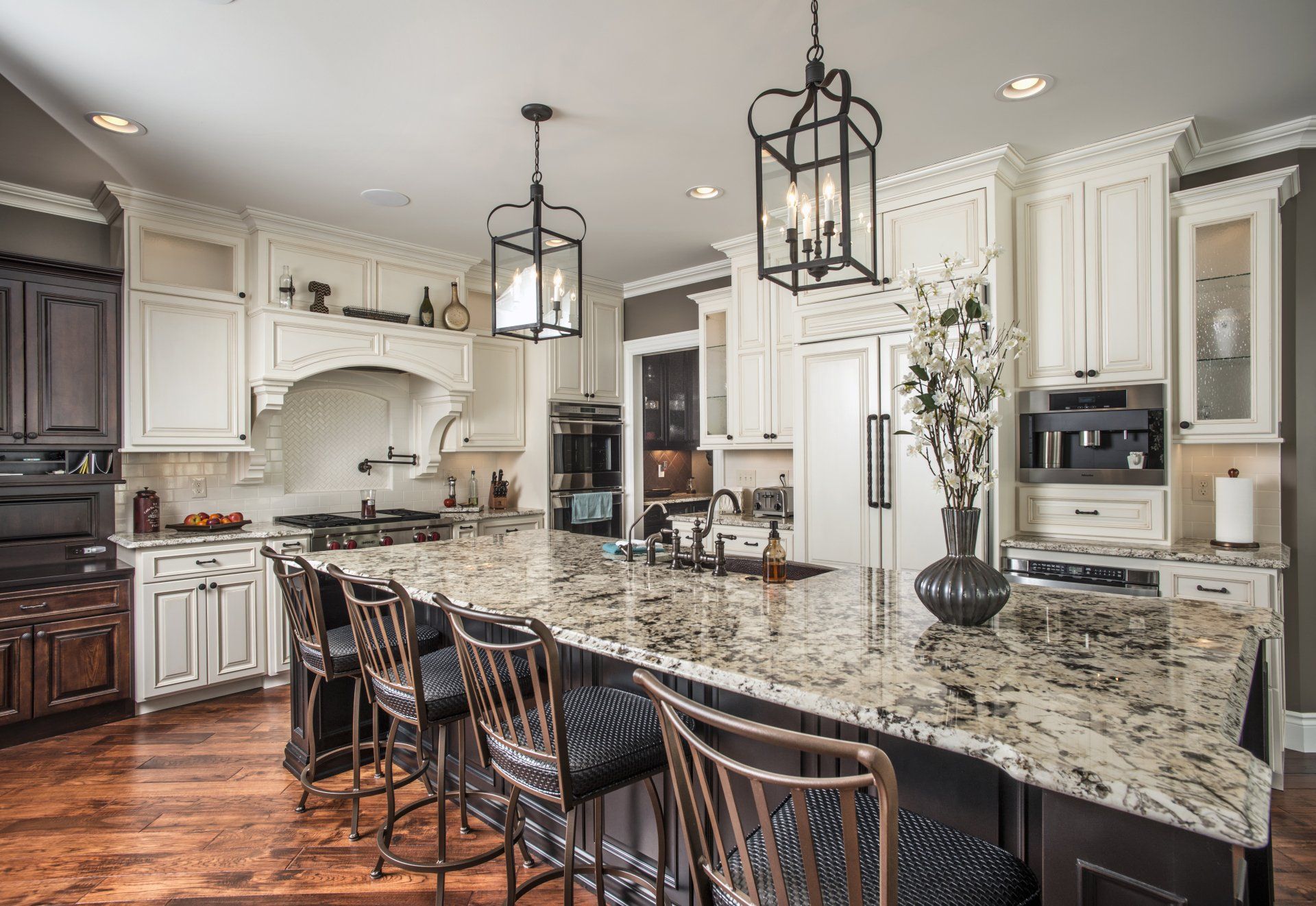 A large kitchen with white cabinets and granite counter tops.