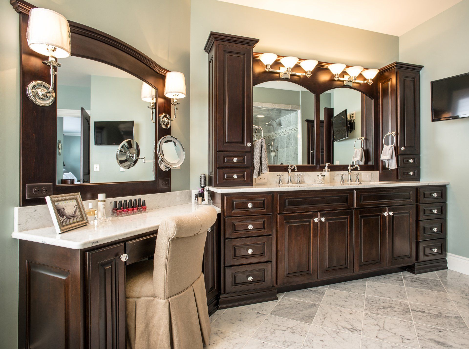 A bathroom with two sinks , two mirrors and a vanity.