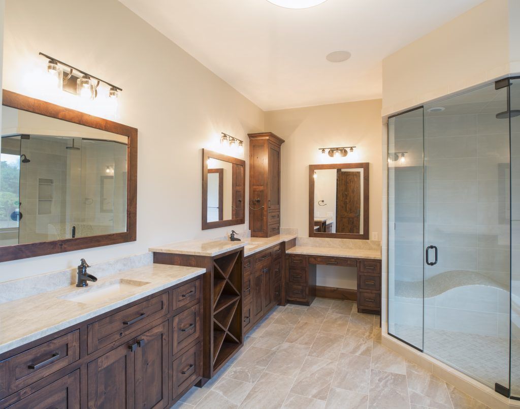 A bathroom with two sinks and a walk in shower.