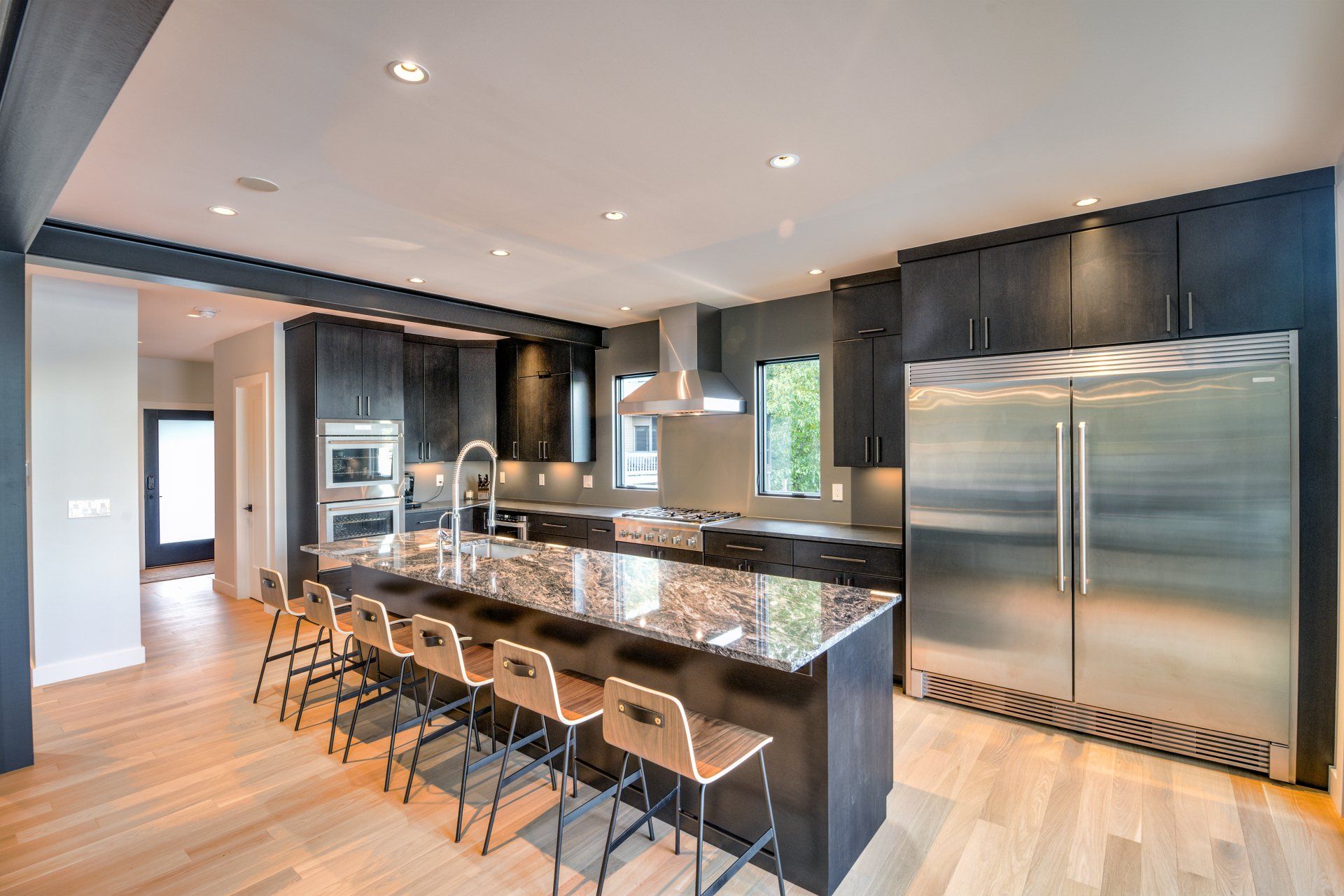 A large beautiful kitchen with stainless steel appliances and granite counter tops.