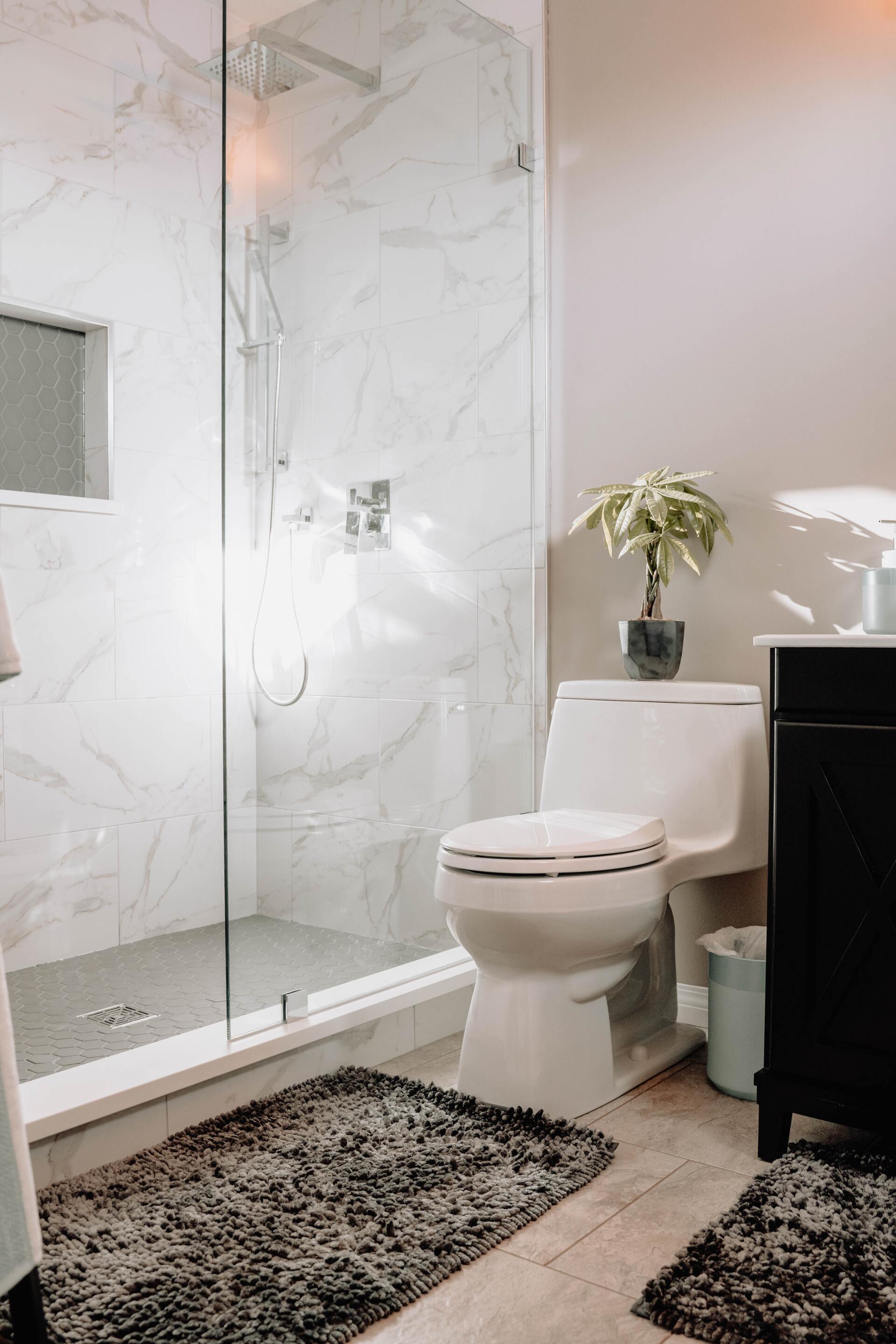 A bathroom with a toilet, sink, and shower.