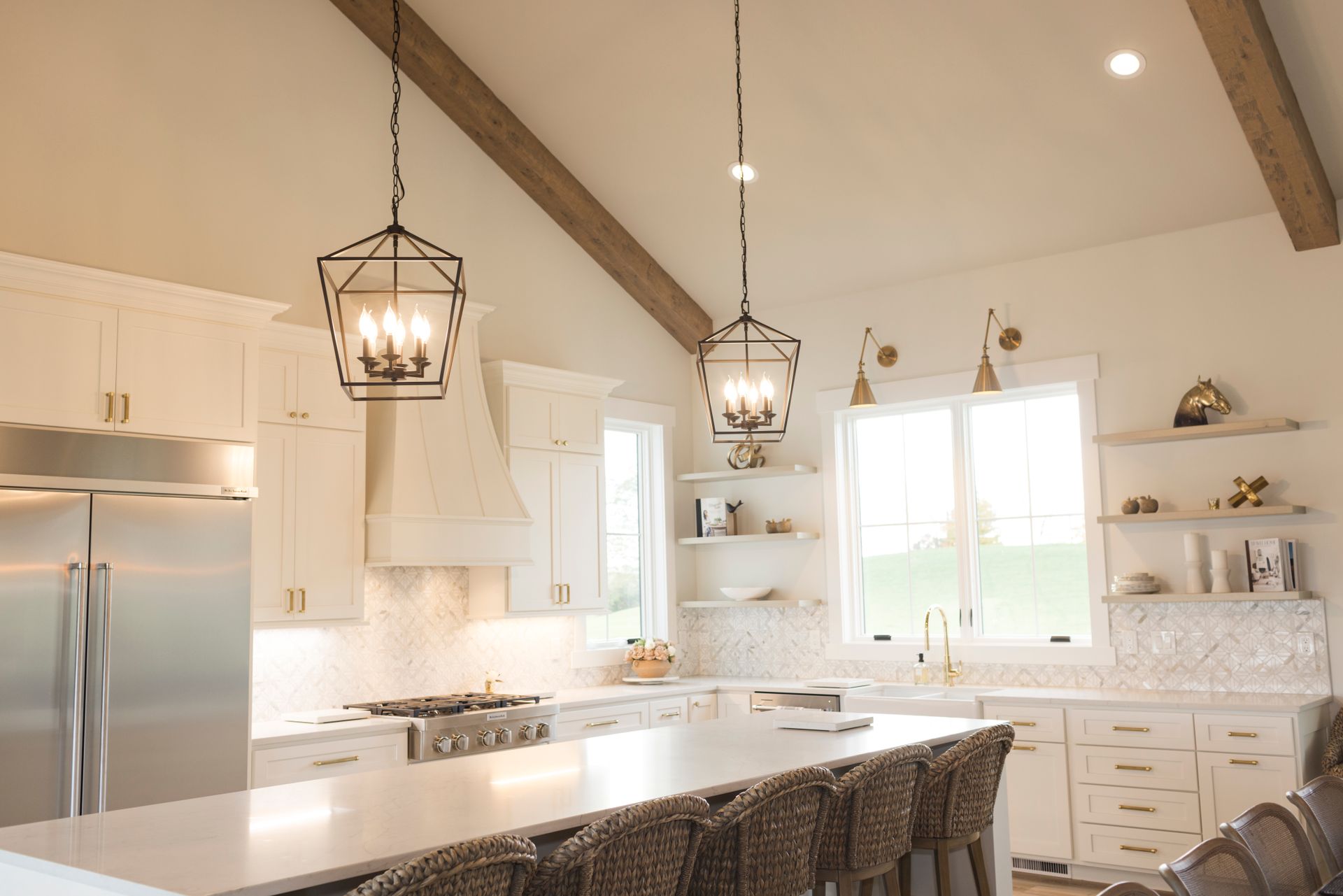 A kitchen with white cabinets and stainless steel appliances and a vaulted ceiling.