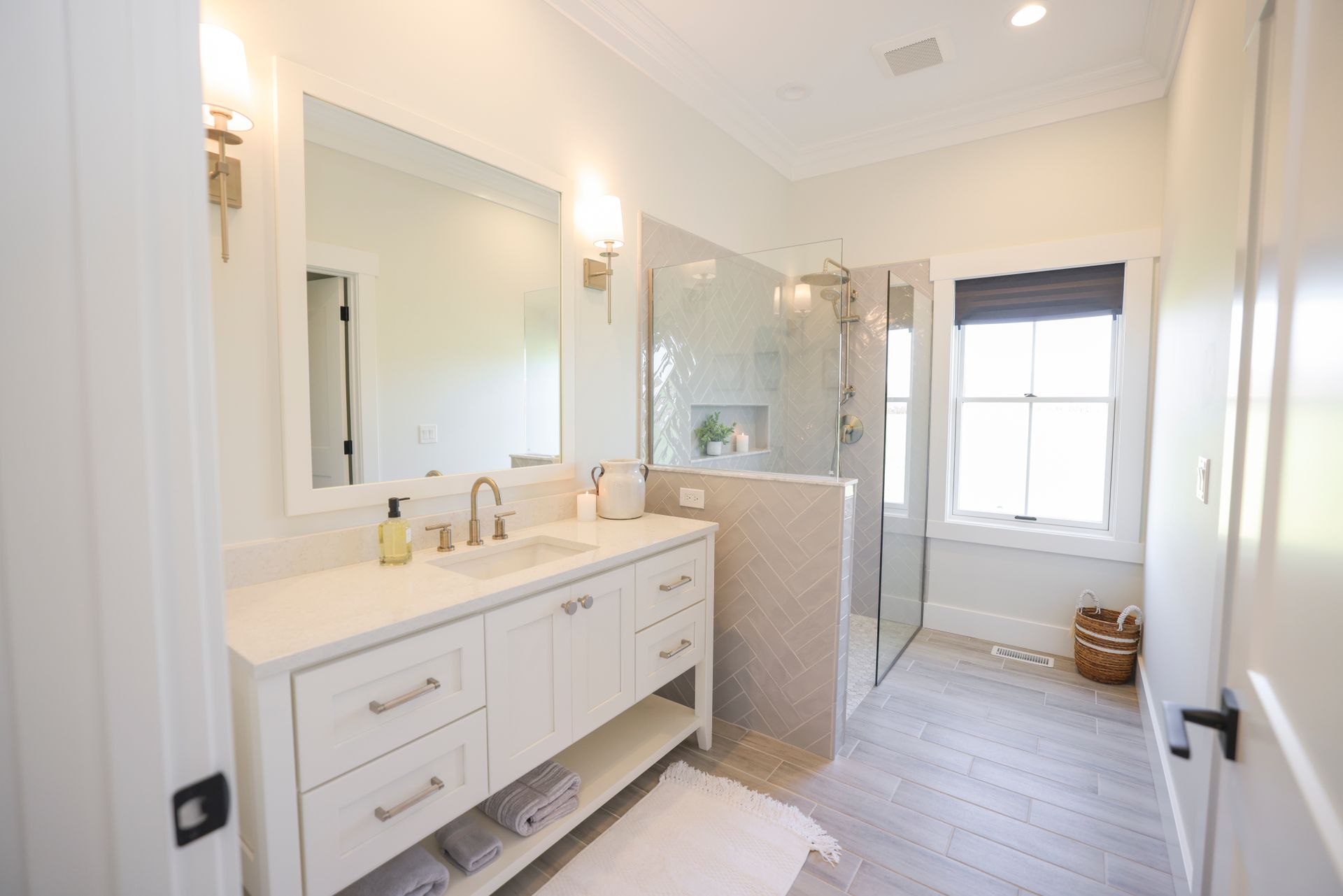 A bathroom with a sink, mirror, and walk in shower.