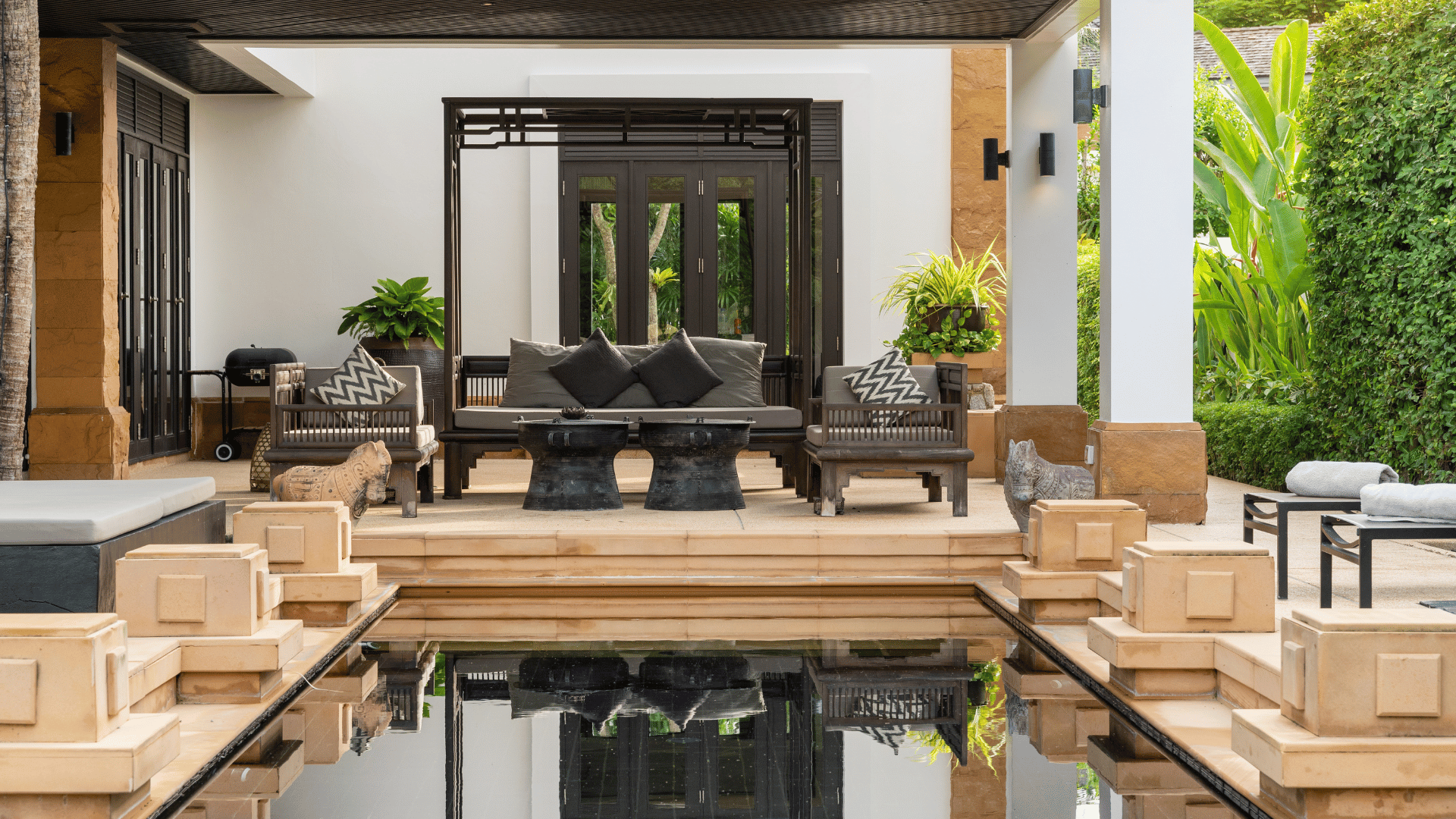 A living room with a couch , table , chairs and a pool.