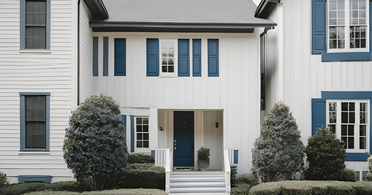 A white house with blue shutters and a blue door.