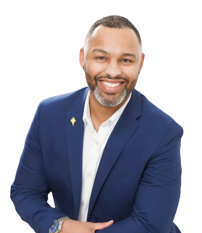 A man in a blue suit and white shirt is smiling for the camera.