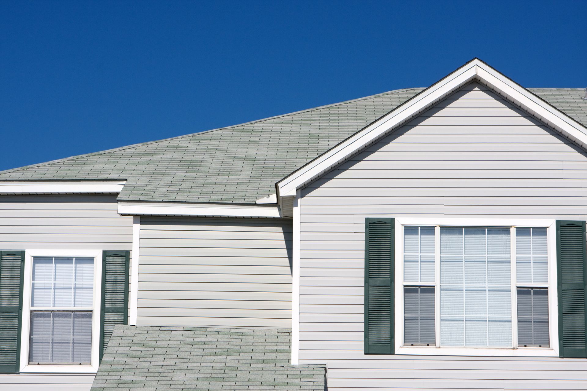 Beautiful house with new roof showcasing expert gutter contractor services and quality gutters.