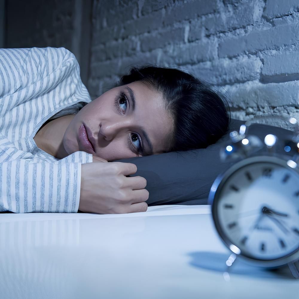 A man is sitting on the floor in front of a window.