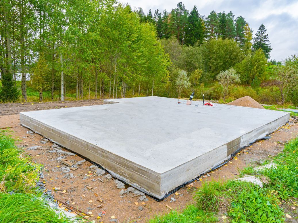 A concrete foundation is being built in the middle of a forest.