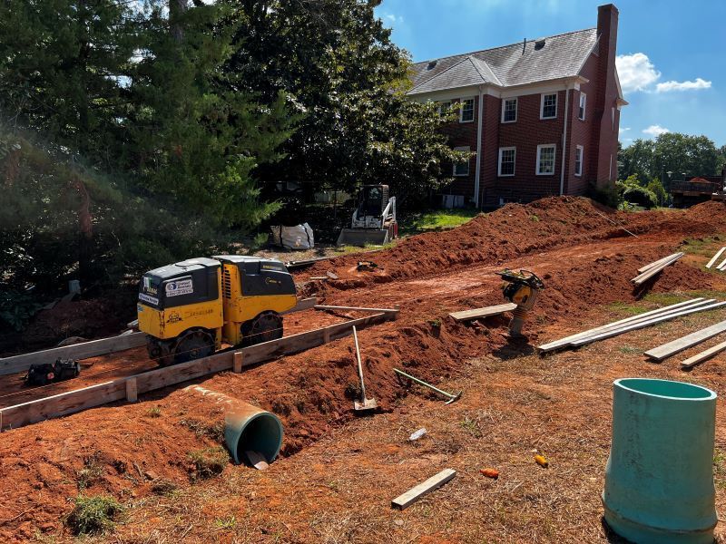 A construction site with a large brick building in the background