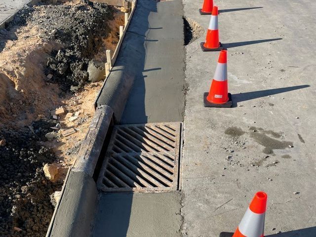 A row of orange and white traffic cones on a sidewalk