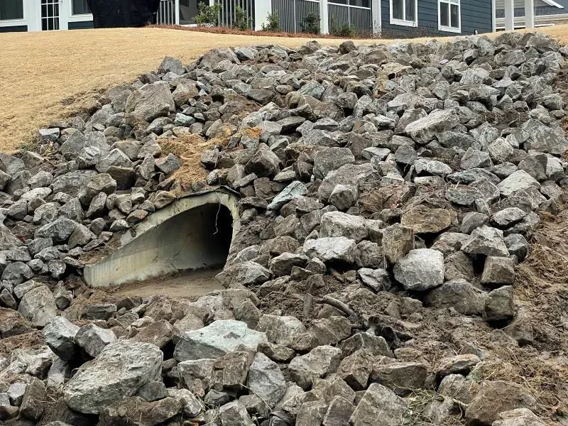 A large pile of rocks with a pipe in the middle of it.