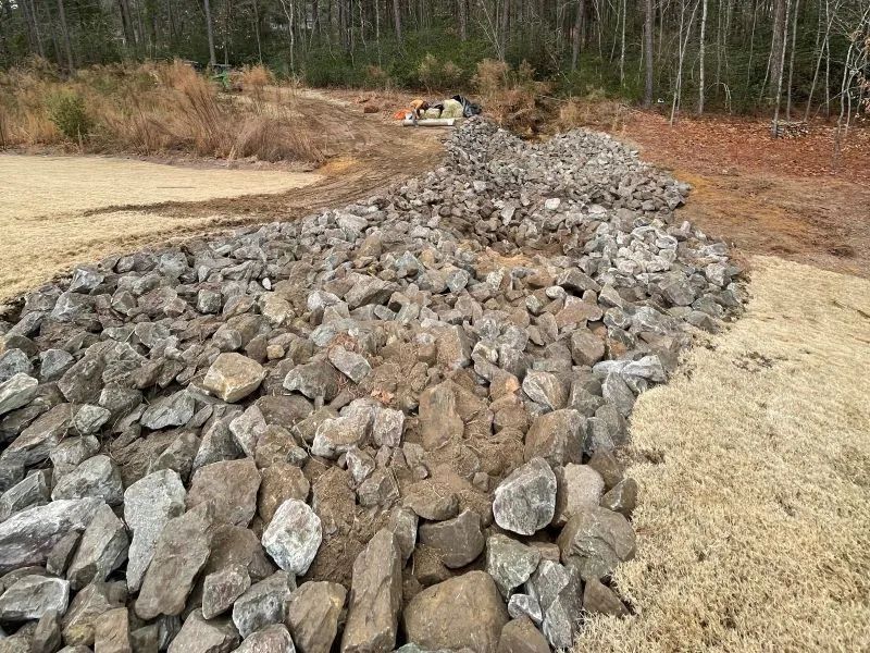 A pile of rocks sitting on top of a dirt field.