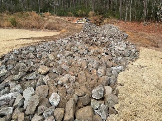A pile of rocks sitting on top of a dirt field.