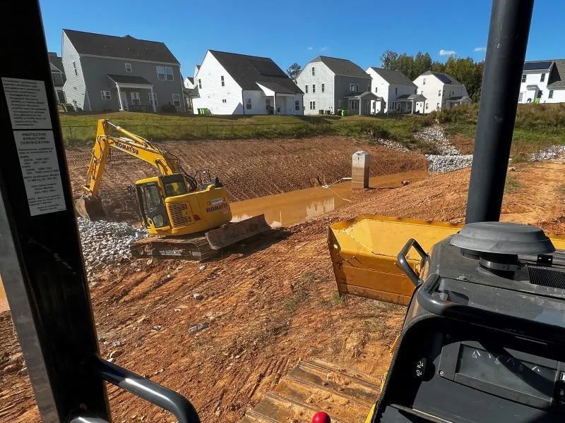 A yellow excavator is moving dirt on a construction site