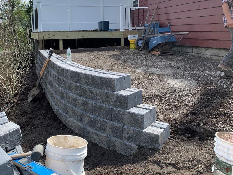 A brick wall is being built in front of a house.