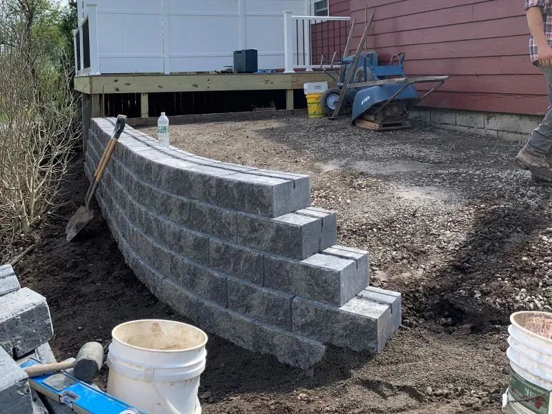 A brick wall is being built in front of a house.