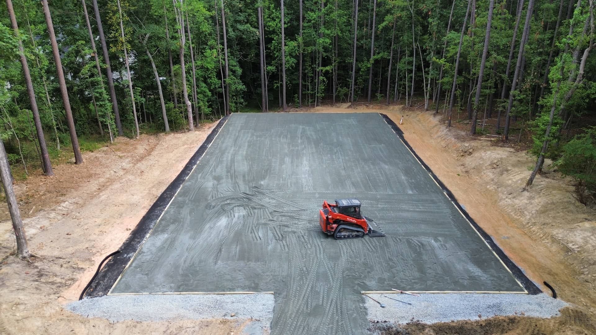 An aerial view of a gravel road in the middle of a forest.