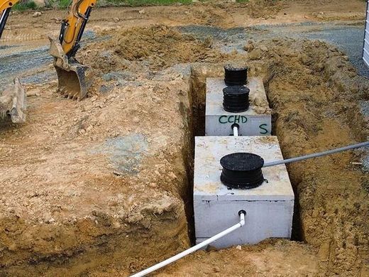 A septic tank is being installed in a hole in the ground.