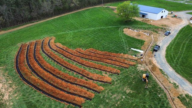 An aerial view of a farm with a lot of rows of dirt.