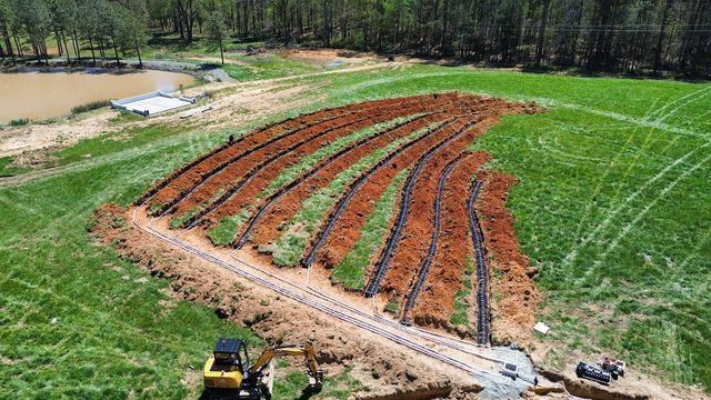 An aerial view of a field with rows of irrigation pipes in it.