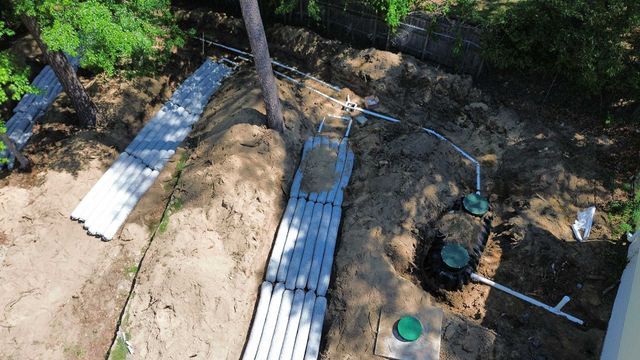 An aerial view of a septic system being installed in a backyard.