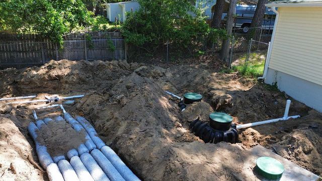 A septic system is being installed in the backyard of a house.