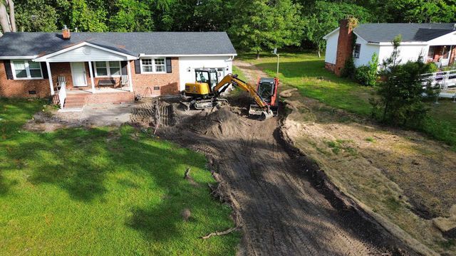 An aerial view of a house with a bulldozer in front of it.