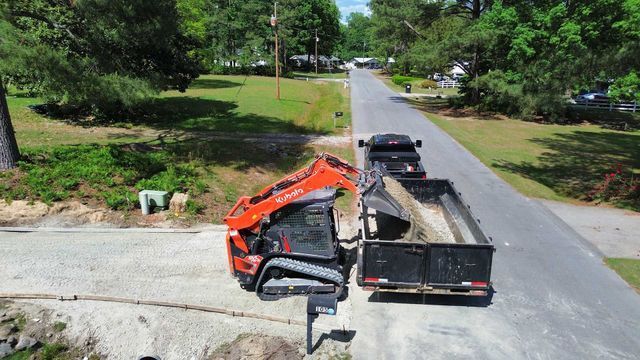 An aerial view of a truck and a bulldozer on a road.