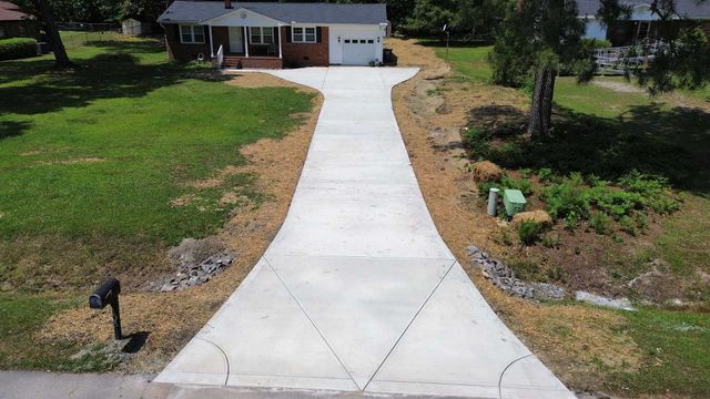 An aerial view of a concrete driveway leading to a house.
