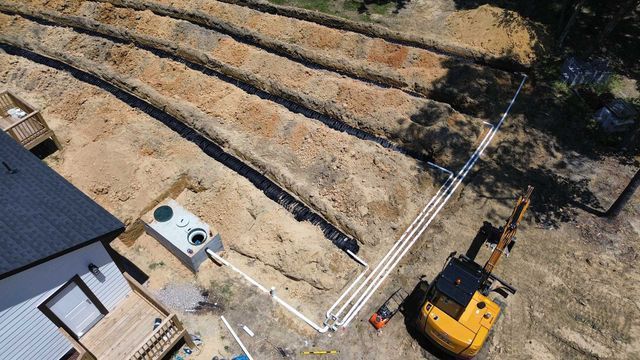 An aerial view of a construction site with a house in the background.