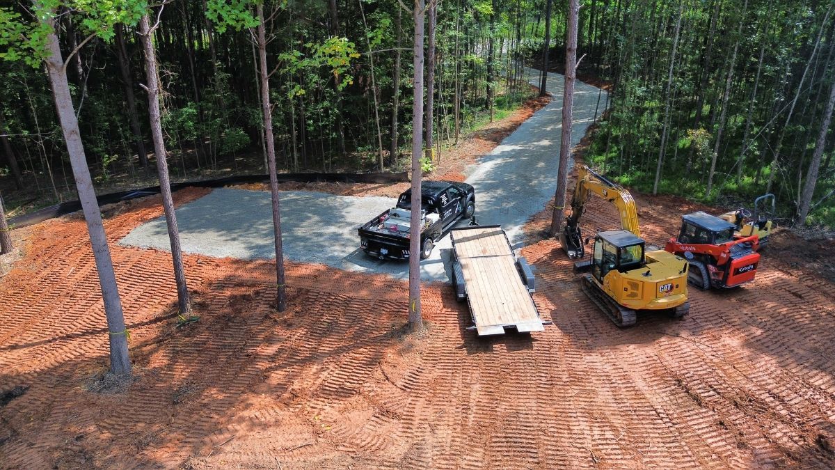An aerial view of a construction site with a truck , excavator , and trailer.