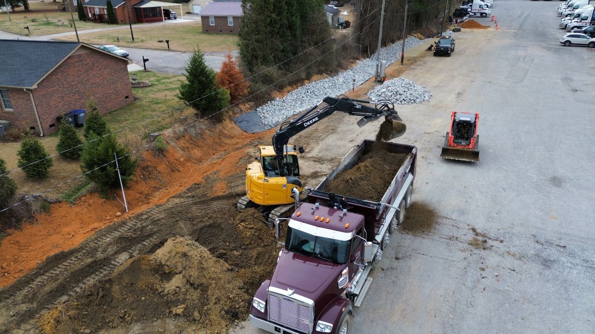 An aerial view of a dump truck being loaded with dirt.