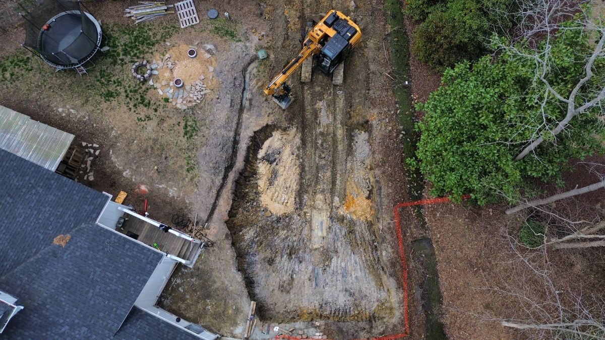 An aerial view of a construction site with a yellow excavator.