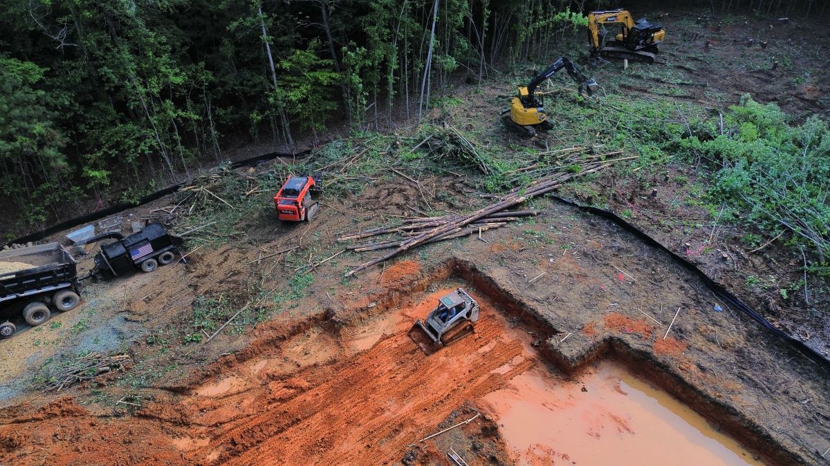 An aerial view of a construction site with a lot of dirt and trucks.