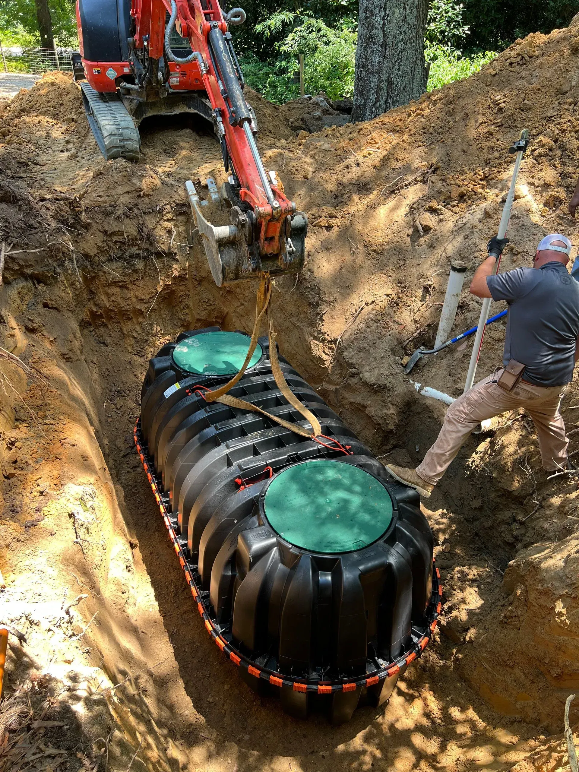 A man is digging a hole to install a septic tank.
