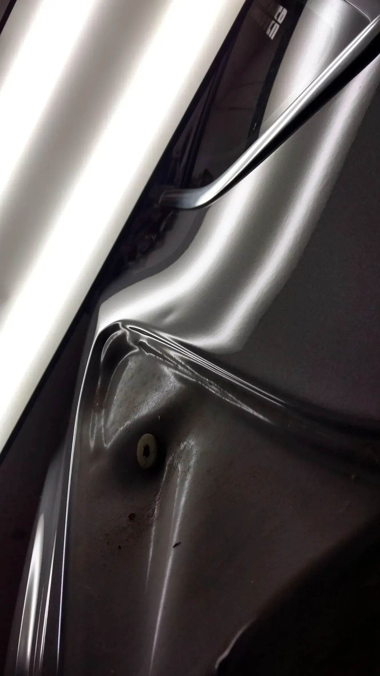 A close up of a car with a dent in the fender.