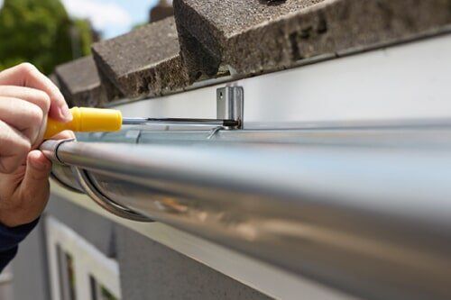 Gutter Installations — Contractor Adjusting Plastic Gutter Guards in Santa Rosa, CA