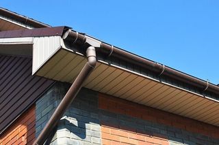 Brick House Rain Gutter With Downspout Pipe — Seamless Gutters Installations in Santa Rosa, CA