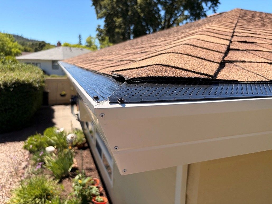 Seamless gutter with perforated leaf guard installed on asphalt shingle roof California Seamless gutter with perforated leaf guard installed on asphalt shingle roof California