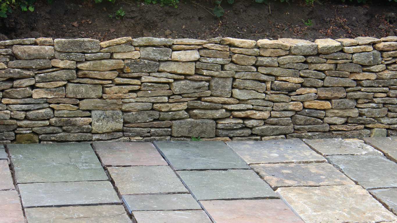 Colorful flower garden with stone retaining wall.