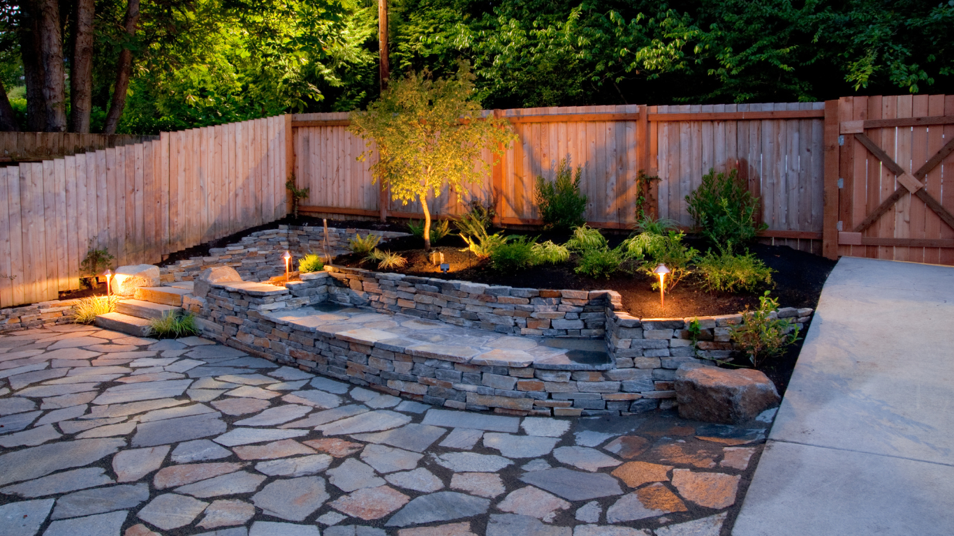 Well-maintained green lawn surrounded by shrubs and trees in a sunny, landscaped setting.