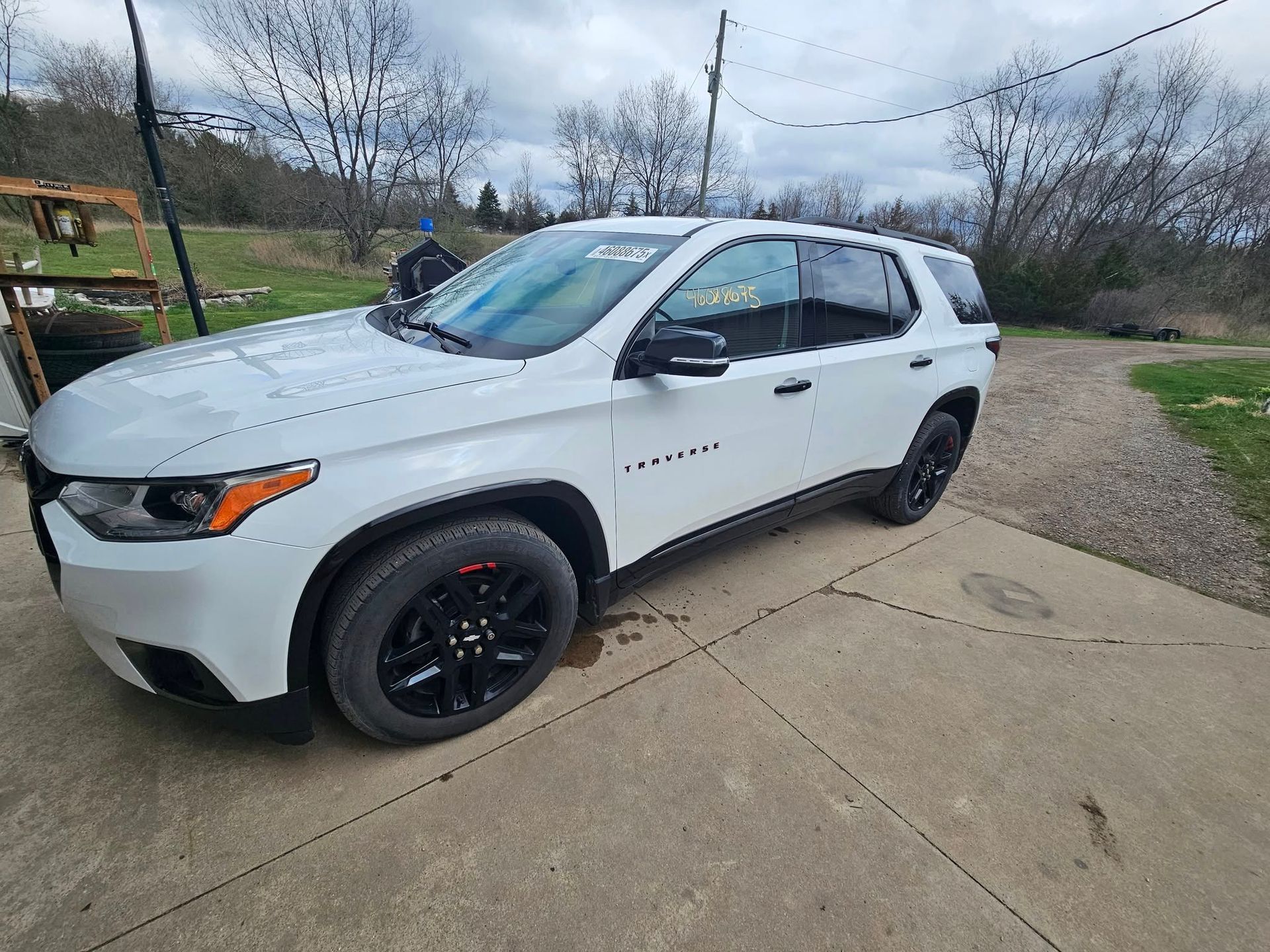 White SUV parked on a concrete surface with black wheels and trim, outdoor setting.