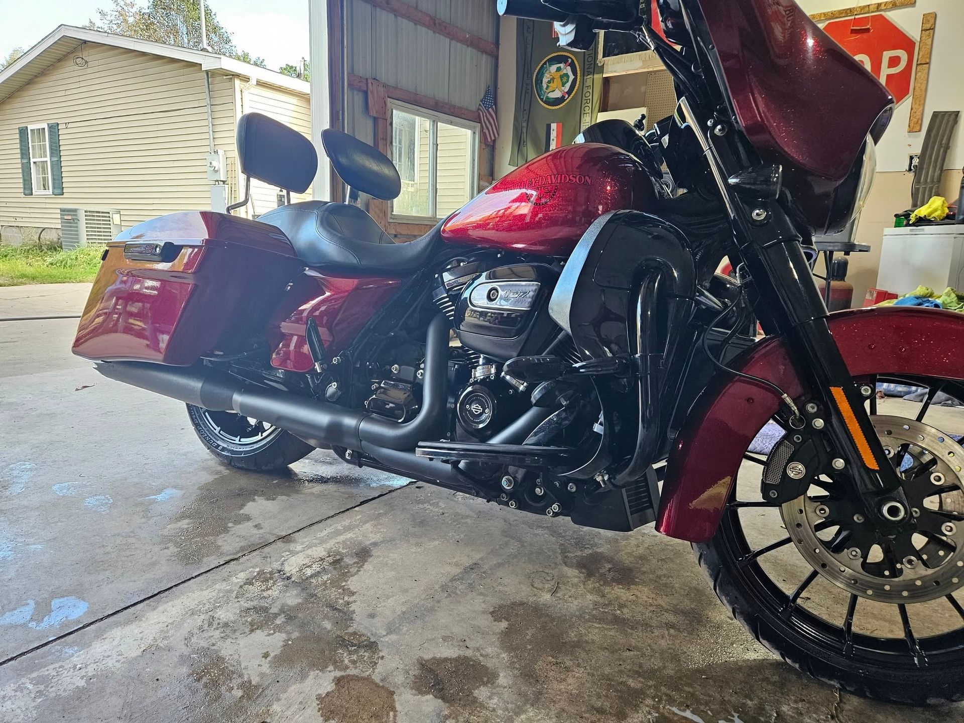 A red and black Harley-Davidson motorcycle parked inside a garage.
