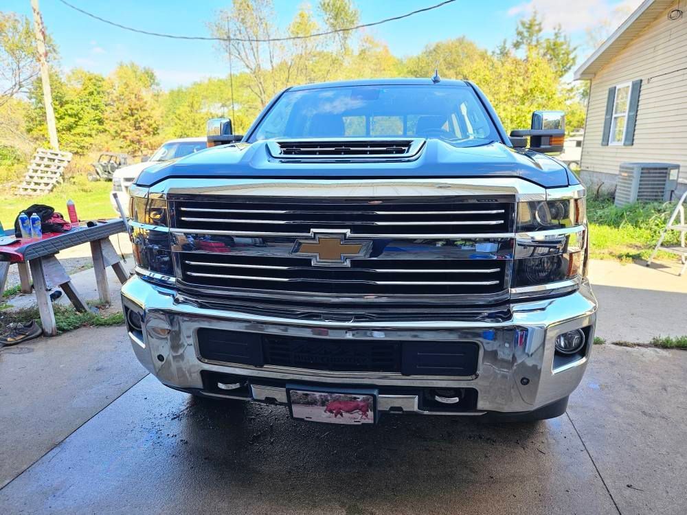 Dark blue Chevrolet truck parked in front of a house on a sunny day.