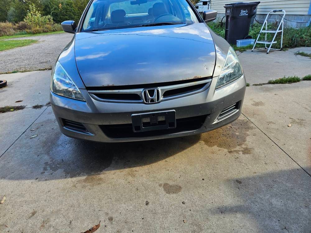 Gray Honda Accord sedan parked on a concrete driveway.
