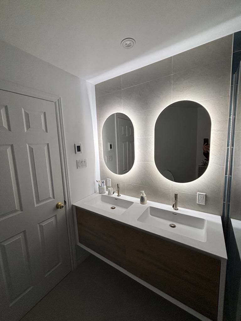 Une salle de bain avec deux lavabos et deux miroirs.