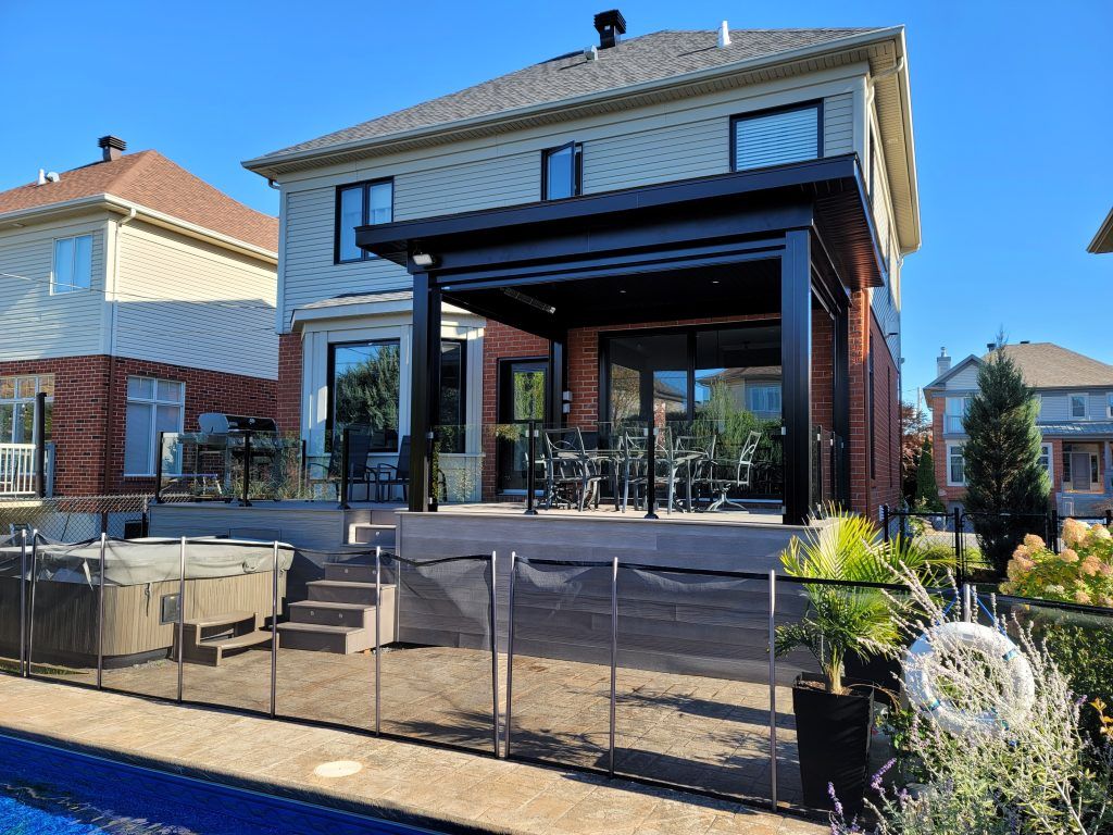 Une grande maison avec un patio et une piscine devant.