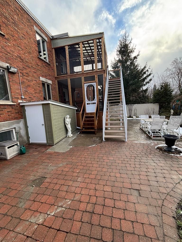 Un patio en briques avec des escaliers menant à une maison.