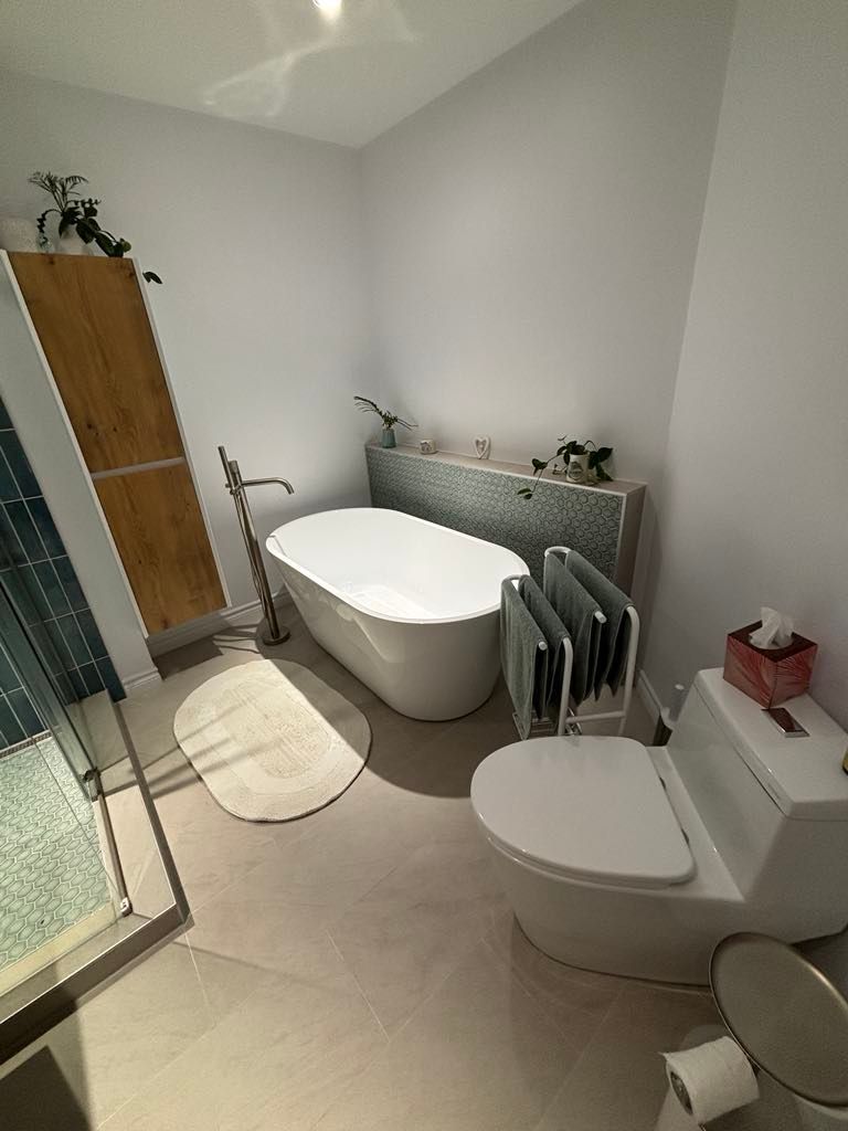 Une salle de bain avec baignoire, toilettes et douche.